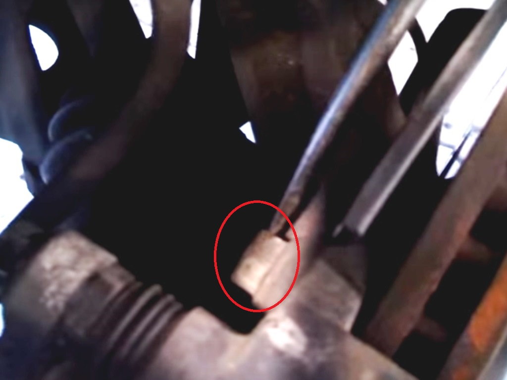 Remove the upper bolt from the caliper bracket