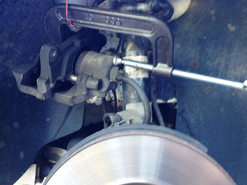 Compress the front piston with a C-clamp