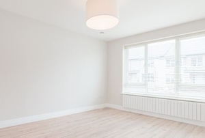 a white empty room with wood floors