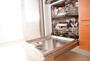 The door to a full dishwasher hangs open.
