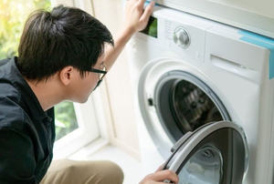 A man looks at a dryer.