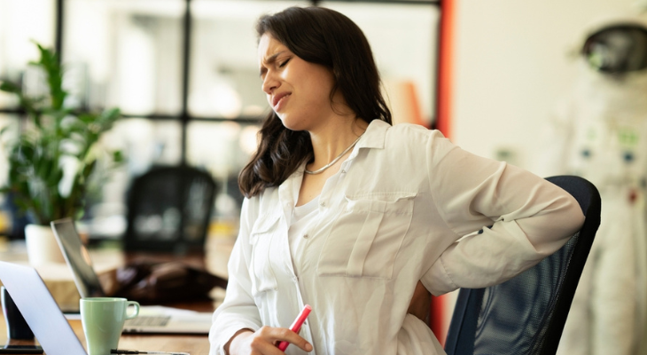 Pained woman holds her back.