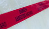 A red tape with the words "danger asbestos hazard."