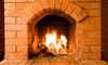 A brick masonry fireplace with a lit fire.