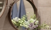 Leather mirror on the wall with flowers in front