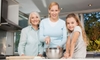 Three generations of women in a kitchen.