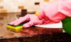 gloved hands washing a countertop with a sponge