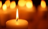 lit candle with others blurred in the background
