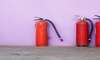 three fire extinguishers against a wall.