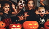 family in halloween costumes with pumpkins