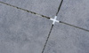 Tile spacer at the intersection of four gray tiles