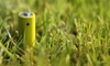 A yellow rechargeable battery sits in the grass.