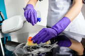 A woman cleans a glass cooktop.