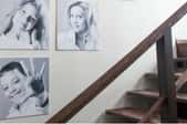 black and white family photos on a wall next to wooden stairs