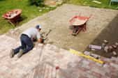 Person installing large area of pavers