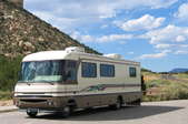 A large motorhome driving along a rural highway.