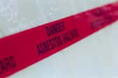 A red tape sign warning against asbestos danger.
