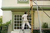 A professional painter working on a home exterior.