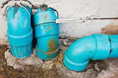 Old, blue PVC pipe with rust stains and damage on the surface.
