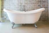 free standing bathtub in brick room