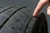 finger checking tire tread