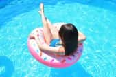 a girl in an inflatable toy in an above ground pool