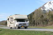 an RV on the road with mountains in the background
