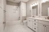 White bathroom with double sinks and two mirrors