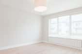 a white empty room with wood floors