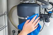 hand with rag cleaning garbage disposal