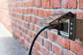 exterior outlet with plug on brick wall