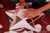 hands making paper bamboo lantern on star frame
