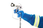 A hand on the trigger of an airless paint sprayer.