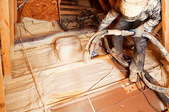 A worker installing blown in insulation in a floor.