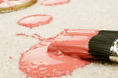 pink paint spilled on a carpet floor with a brush