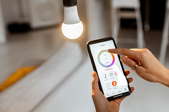 hand using phone to control smart light