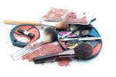 A couple palettes of spilled makeup and makeup brushes.