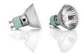 Two halogen light bulbs on a reflective white surface.