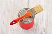 A paintbrush sitting on a paint can.
