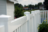 a row of white vinyl fencing