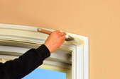 Painting old, white, wood trim with a new off-white paint.