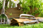 gardening tools on grass by planter box