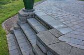 Steps leading into the yard from a paver patio.