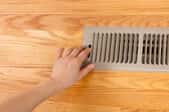 Closing a floor vent grille using the lever.