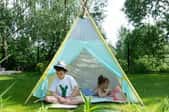 kids relaxing in a teepee made with patterned sheets in an outdoor area