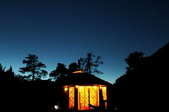 A lit yurt against a nighttime sky. 