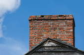 A brick chimney in front of a blue sky.