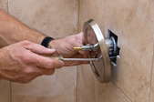 A man repairs a shower faucet.