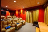 A home theater room with large, leather chairs.