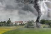 tornado whirling through green field